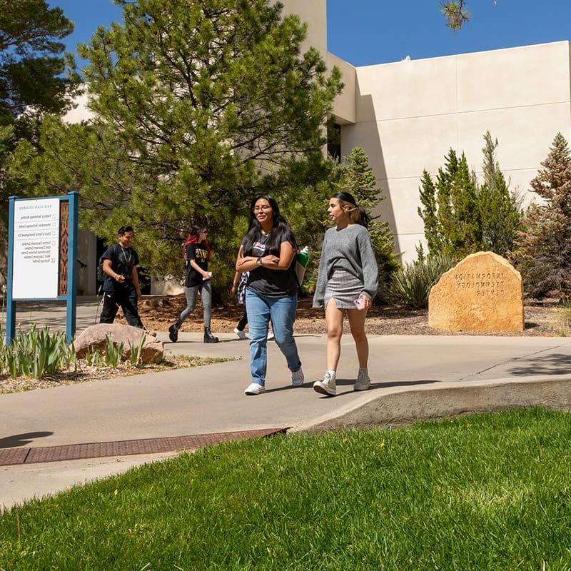 Student walking on the San Juan College Campus near the IT building